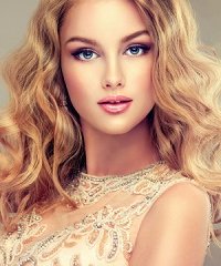 Young beautiful woman, dressed in evening gown. Loose,wavy hair and bright make up.
